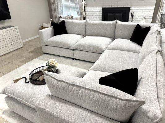 Sectional sofa in a living room with decorative pillows and a rug.