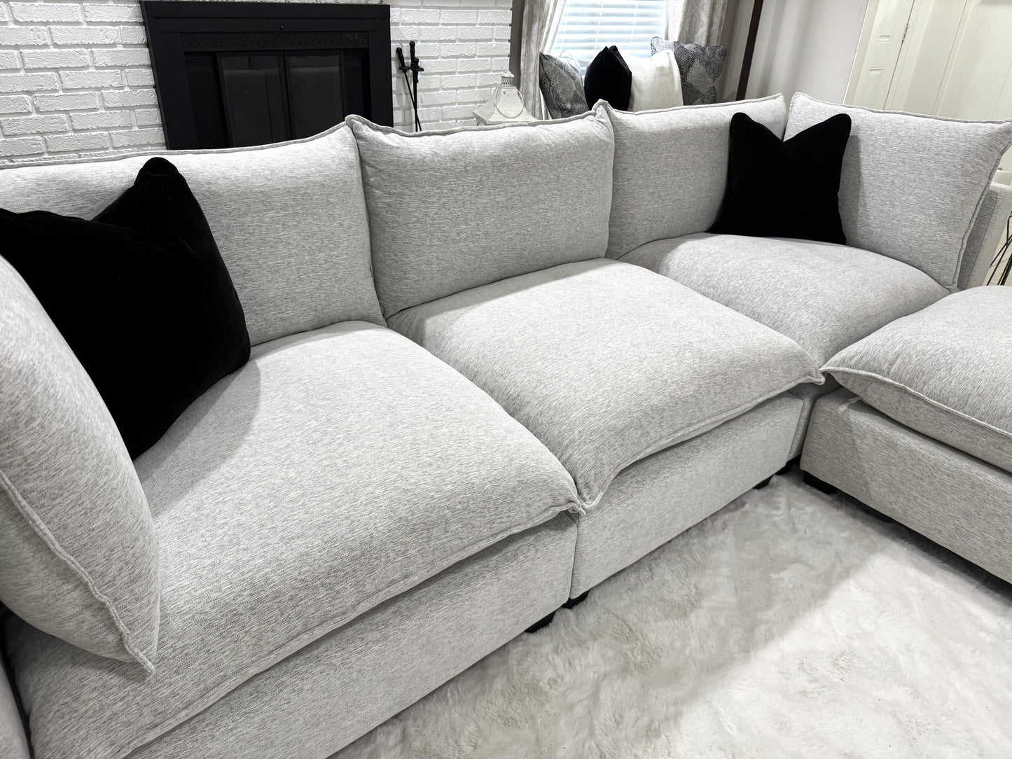 Sofa with black pillows in a living room setting.