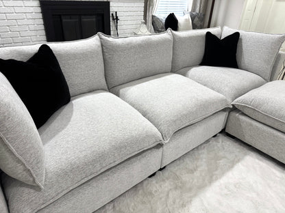 Sofa with black pillows in a living room setting.