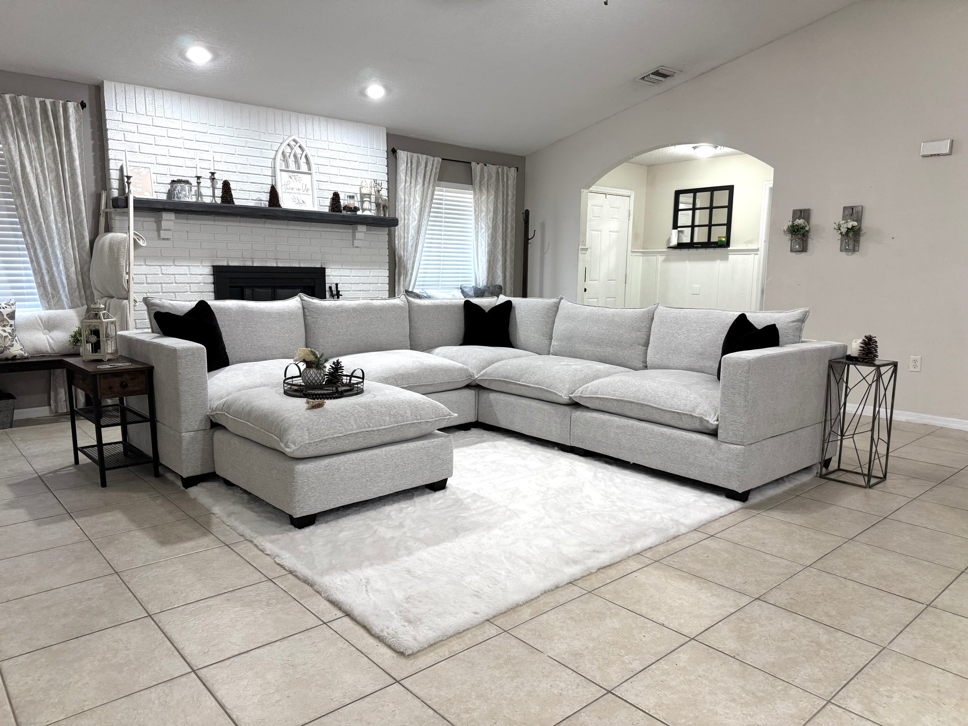Modern living room with a sectional sofa, coffee table, and decorative items.