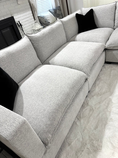 Sectional sofa with black cushions in a living room setting.