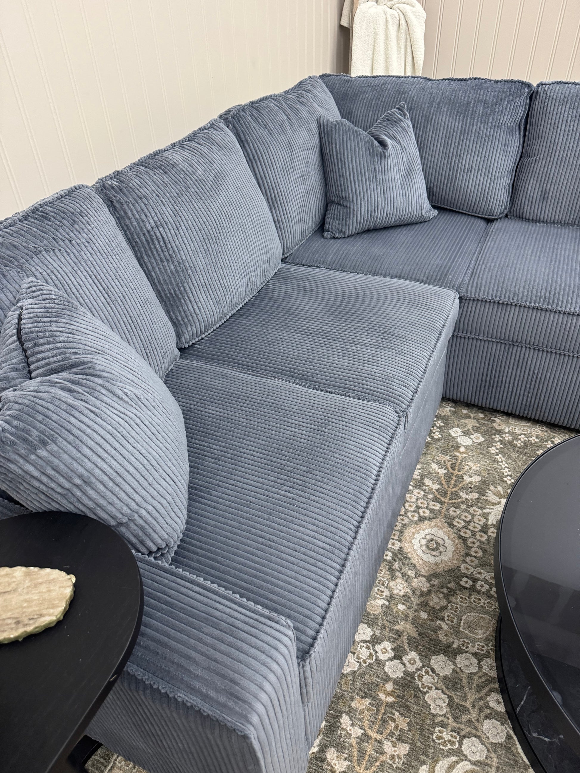 Sectional sofa in a living room setting with a patterned rug.