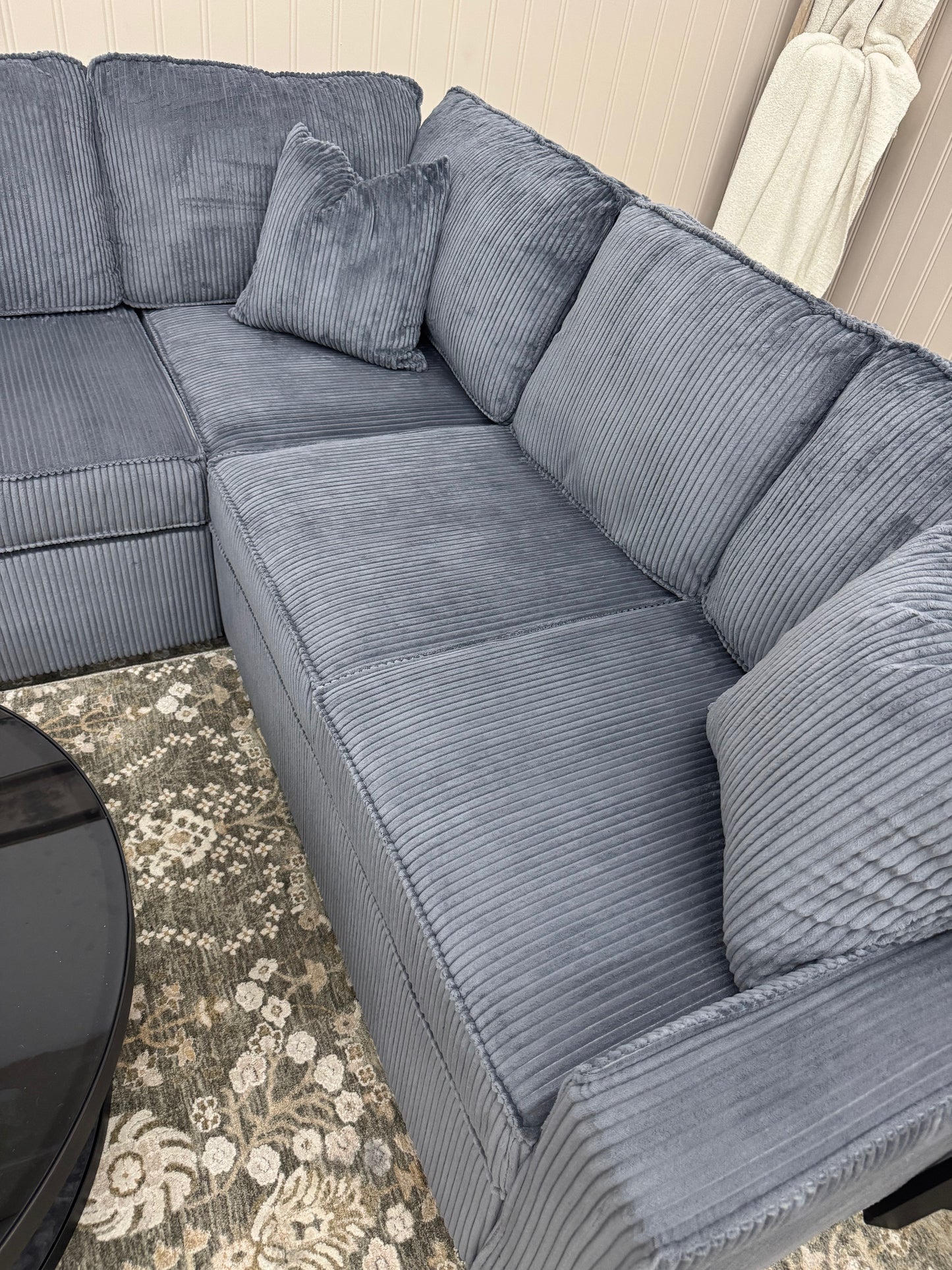 Sectional sofa with textured cushions on a patterned rug.