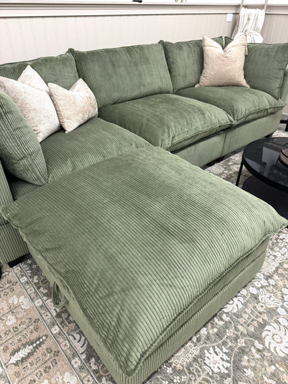 Green sofa on a patterned rug.