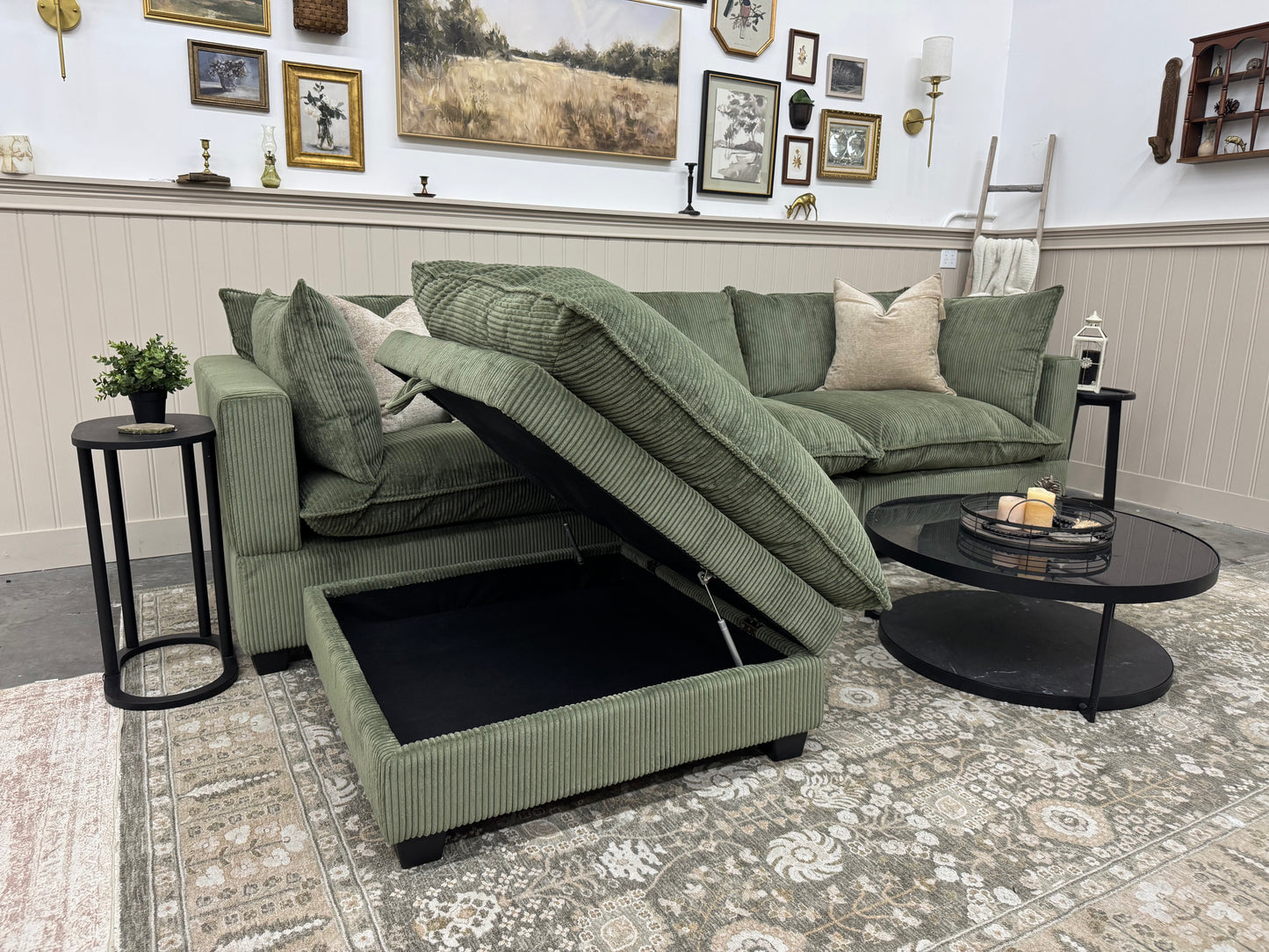Green sofa with storage ottoman in a living room setting.